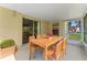 Covered patio with a wood table, six chairs, and a view of a grassy backyard at 13146 Odyssey Lake Way, Orlando, FL 32826