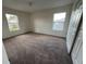 Neutral bedroom features brown carpet, two windows and a white closet door at 1325 Bella Coola Dr, Orlando, FL 32828