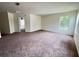 Bonus room features neutral walls, brown carpet, an open doorway and a bright window at 1325 Bella Coola Dr, Orlando, FL 32828