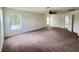 This bonus room has neutral walls, carpeting, ceiling fan, and lots of natural light from three windows at 1325 Bella Coola Dr, Orlando, FL 32828