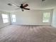 Bonus room has neutral walls, carpeting, a ceiling fan, and lots of natural light from three windows at 1325 Bella Coola Dr, Orlando, FL 32828