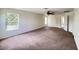 Bonus room has neutral walls, carpeting, a ceiling fan, and lots of natural light from three windows at 1325 Bella Coola Dr, Orlando, FL 32828