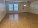 Bright living room features tile flooring, two large windows and a front door at 1325 Bella Coola Dr, Orlando, FL 32828