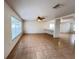 Spacious living room featuring tile flooring, neutral paint, ceiling fan, and passthrough to kitchen at 1325 Bella Coola Dr, Orlando, FL 32828