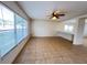 Bright living room with tile flooring, neutral paint, large windows, and modern ceiling fan at 1325 Bella Coola Dr, Orlando, FL 32828