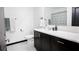 Bright bathroom featuring a modern vanity with a white countertop, dark cabinets, and a shower/tub with patterned curtain at 13851 Rushing Creek Run, Orlando, FL 32824