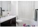 Cozy bathroom featuring modern vanity and fixtures, with an adjacent shower with curtain at 13851 Rushing Creek Run, Orlando, FL 32824