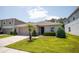 Well-maintained single-story home with a manicured lawn, decorative shrubbery, and attached two-car garage at 13851 Rushing Creek Run, Orlando, FL 32824