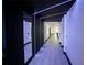 Modern hallway featuring unique architectural lighting and contrasting dark paneled walls at 13851 Rushing Creek Run, Orlando, FL 32824