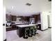 Modern kitchen with a center island, breakfast bar, pendant lighting, and sleek black bar stools at 13851 Rushing Creek Run, Orlando, FL 32824