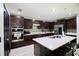 Kitchen with dark cabinets, stainless appliances, island with seating and modern backsplash at 13851 Rushing Creek Run, Orlando, FL 32824