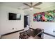 Modern home office with flat screen TV, decorative painting, black desk, tiled floors, and ample space at 13851 Rushing Creek Run, Orlando, FL 32824