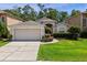 Charming single-story home with a well-manicured lawn, two car garage, and welcoming front entrance at 14780 Hartford Run Dr, Orlando, FL 32828