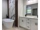 Modern bathroom featuring a freestanding tub, marbled wall accent, and double vanity sinks with black hardware at 16494 Sw 54Th Court Rd, Ocala, FL 34473