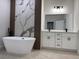 Elegant bathroom with a soaking tub, decorative marble wall, and double vanity with modern lighting at 16494 Sw 54Th Court Rd, Ocala, FL 34473