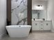 Elegant bathroom showcases a freestanding tub, stylish marble wall, and double vanity with sleek, modern design at 16494 Sw 54Th Court Rd, Ocala, FL 34473