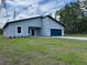 Charming single-story home with a blue garage door and a well-manicured front lawn at 16494 Sw 54Th Court Rd, Ocala, FL 34473