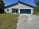 Charming single-story home with a blue garage door and a well-manicured front lawn at 16494 Sw 54Th Court Rd, Ocala, FL 34473