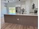 Modern kitchen island featuring elegant waterfall countertop and a stylish wood-finished base at 16494 Sw 54Th Court Rd, Ocala, FL 34473