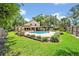 Lush backyard with a beautiful pool area, mature landscaping, and a well-manicured lawn at 1905 Old Club Pt, Maitland, FL 32751