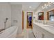 Bright bathroom featuring a soaking tub, walk-in closet, and double vanity at 1905 Old Club Pt, Maitland, FL 32751