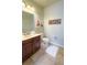 Well-lit bathroom featuring a vanity with dark wood cabinets, a toilet, and nautical-themed decor at 206 Yellow Snapdragon Dr, Davenport, FL 33837