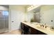 Bathroom featuring double sinks, a large mirror, and a walk-in shower at 206 Yellow Snapdragon Dr, Davenport, FL 33837