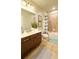 Well-lit bathroom with granite counters, dark cabinets, tiled shower/tub, and neutral tile floors at 206 Yellow Snapdragon Dr, Davenport, FL 33837