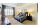 Primary bedroom featuring neutral carpet, shuttered windows, and nautical themed decorations at 206 Yellow Snapdragon Dr, Davenport, FL 33837