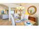 Bright dining room with a decorative mirror, chandelier, and a view of the living area at 206 Yellow Snapdragon Dr, Davenport, FL 33837