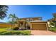Two-story home with a paved driveway, lush landscaping, and a well-maintained lawn on a sunny day at 206 Yellow Snapdragon Dr, Davenport, FL 33837