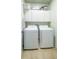 Efficient laundry room with a side-by-side washer and dryer, and overhead storage cabinets at 206 Yellow Snapdragon Dr, Davenport, FL 33837