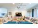 Bright living room with comfortable seating, large TV, ceiling fan, and staircase in view at 206 Yellow Snapdragon Dr, Davenport, FL 33837