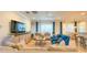 Spacious living room with neutral tones, blue accents, a ceiling fan and a large TV at 206 Yellow Snapdragon Dr, Davenport, FL 33837