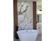 Modern bathroom featuring soaking tub, marble accent wall, and vanity with storage at 2336 Sw 168Th Loop, Ocala, FL 34473