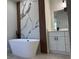 Modern bathroom featuring soaking tub, marble accent wall, and vanity with storage at 2336 Sw 168Th Loop, Ocala, FL 34473