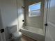Modern bathroom with a white toilet and a bathtub with white tiles at 2336 Sw 168Th Loop, Ocala, FL 34473