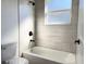 This bathroom features a shower and tub combination, bright window, and black hardware at 2336 Sw 168Th Loop, Ocala, FL 34473