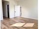 Bedroom with wood-look floors and white doors leading to the closet and other rooms at 2336 Sw 168Th Loop, Ocala, FL 34473