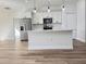 Modern kitchen featuring white cabinetry, stainless steel appliances, and wood-look flooring at 2336 Sw 168Th Loop, Ocala, FL 34473