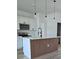 Kitchen island with wood trim and white countertops, pendant lighting, and stainless appliances at 2336 Sw 168Th Loop, Ocala, FL 34473