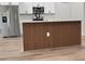 Kitchen island with wood trim, white cabinets, stainless steel appliances, and plank floors at 2336 Sw 168Th Loop, Ocala, FL 34473
