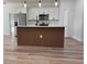 Modern open kitchen features sleek wooden-paneled island, stainless appliances, and ample counter space at 2336 Sw 168Th Loop, Ocala, FL 34473