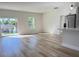 Open-concept living room with wood-look floors, natural light, and modern kitchen view at 2336 Sw 168Th Loop, Ocala, FL 34473