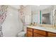 Bright bathroom featuring a white tile bath and vanity with light countertop and colorful shower curtain at 2345 White Buffalo St, Apopka, FL 32703