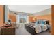 Cozy bedroom featuring a comfortable bed, neutral and orange walls, and bright window at 2345 White Buffalo St, Apopka, FL 32703
