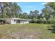 A large backyard with mature trees and a screened-in porch, perfect for outdoor activities and relaxation at 2536 Nw 3Rd Ave, Ocala, FL 34475