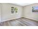 Cozy bedroom with wood-look flooring and two windows offering a view of the outdoors at 2536 Nw 3Rd Ave, Ocala, FL 34475