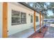 A view of the front porch with wood columns, newly planted landscaping, and a white front door with gray trim at 2536 Nw 3Rd Ave, Ocala, FL 34475