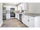 Modern kitchen with white cabinets, granite countertops, stainless steel appliances, and gray wood floors at 2536 Nw 3Rd Ave, Ocala, FL 34475